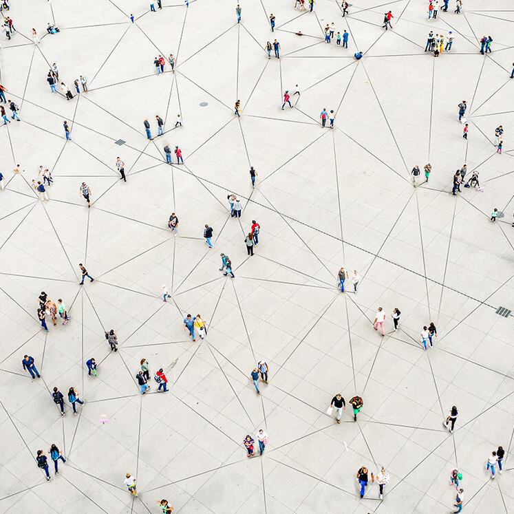 Viele Personen stehen verstreut und sind über schwarze Linien miteinander verbunden. | © iStock/Orbon Alija