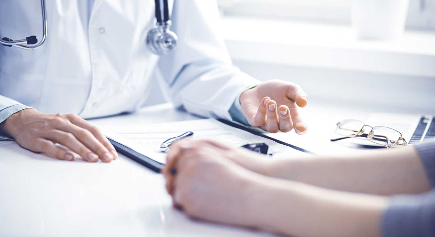 Hausarzt im Gespräch mit einer Patientin.