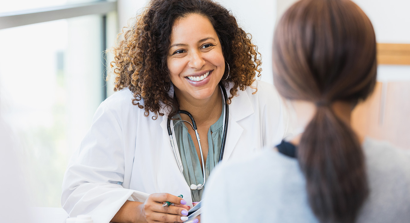 Hausärztin im Gespräch mit einer jungen Patientin.