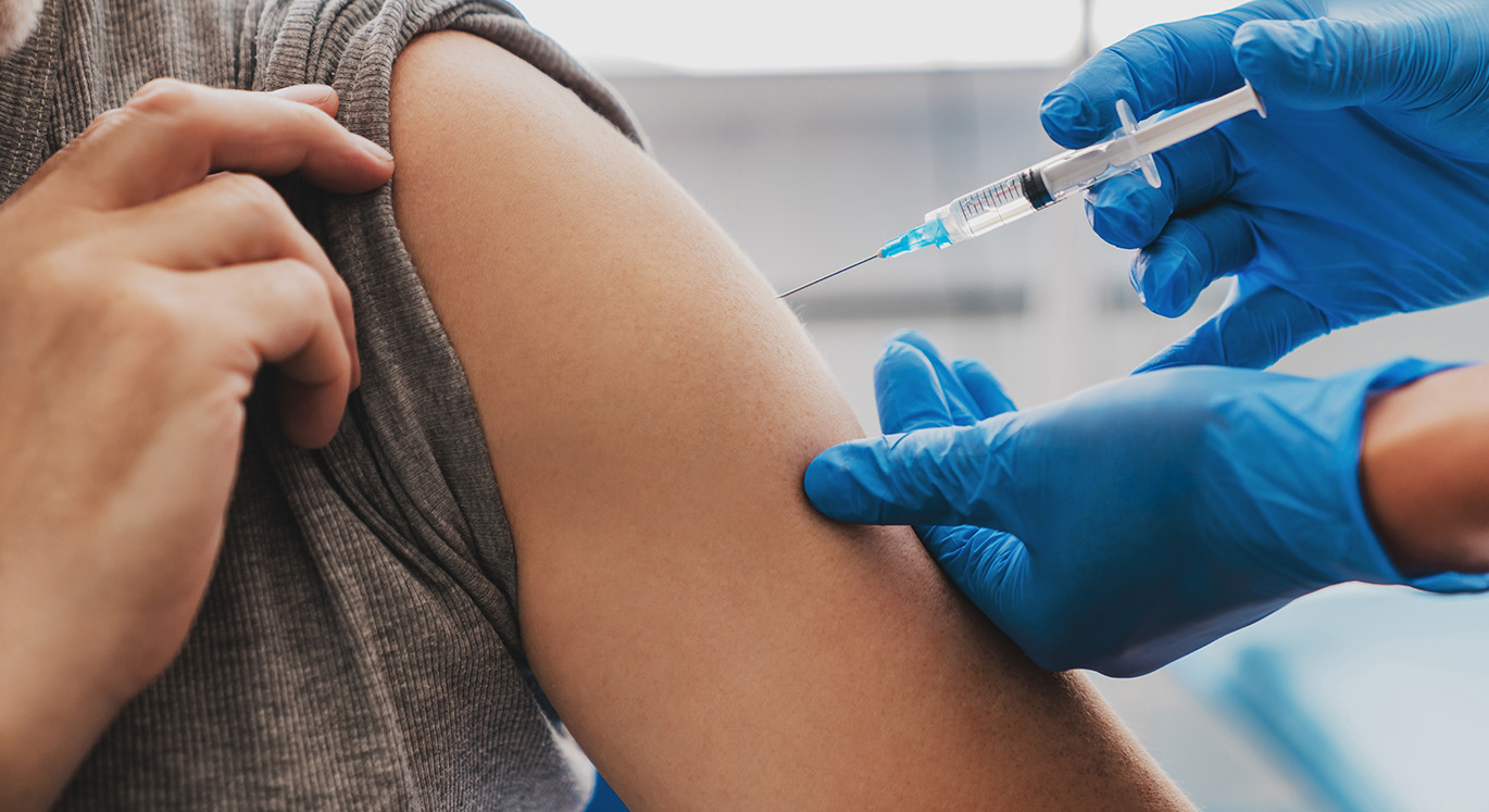Patientin wird in der Hausarztpraxis in den linken Arm geimpft.